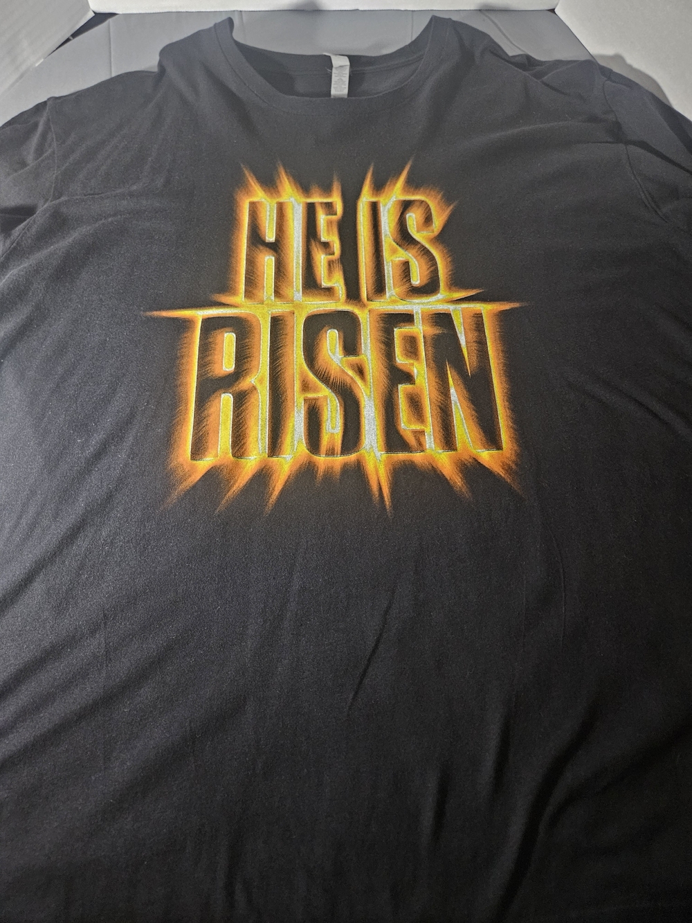 Next Level Apparel Black Tee with Fiery Yellow-Orange 'He Is Risen' Graphic